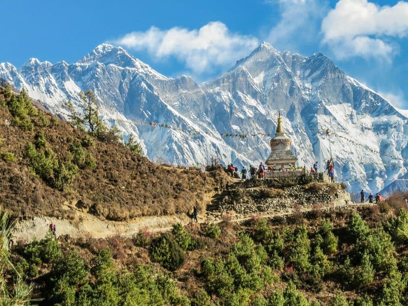 A stupa on a ridge below the snowy peaks of the Everest range