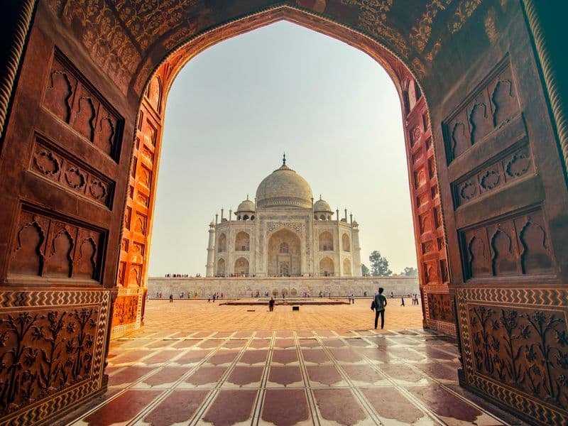 The Taj Mahal seen through a carved sandstone archway