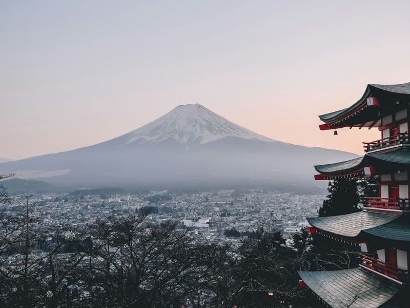 Mount Fuji behind a red pagoda at dusk