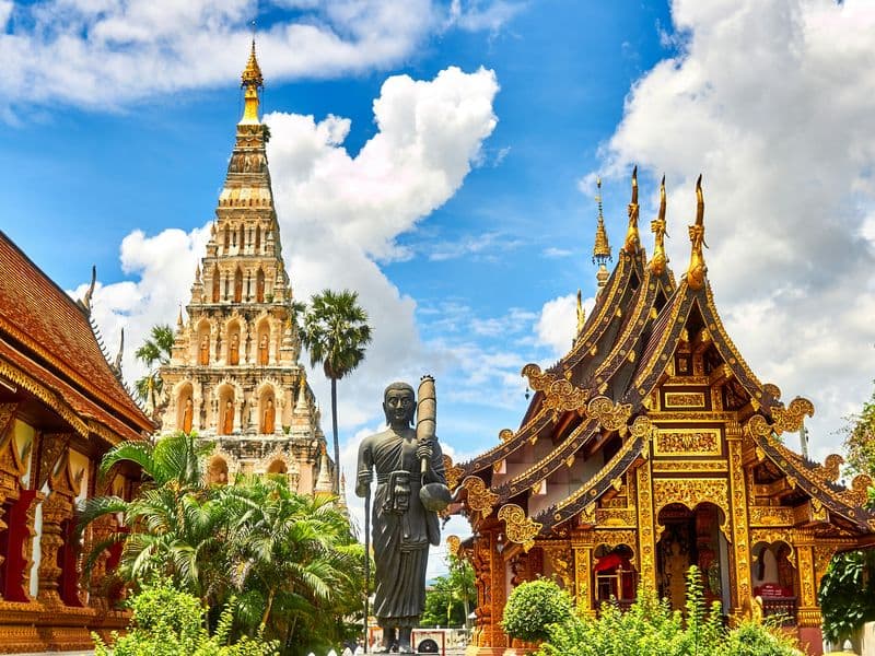 Golden temple spires in northern Thailand under a blue sky