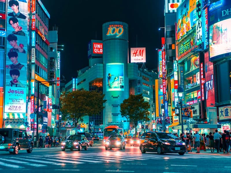 Neon signs and traffic at a busy Tokyo crossing at night
